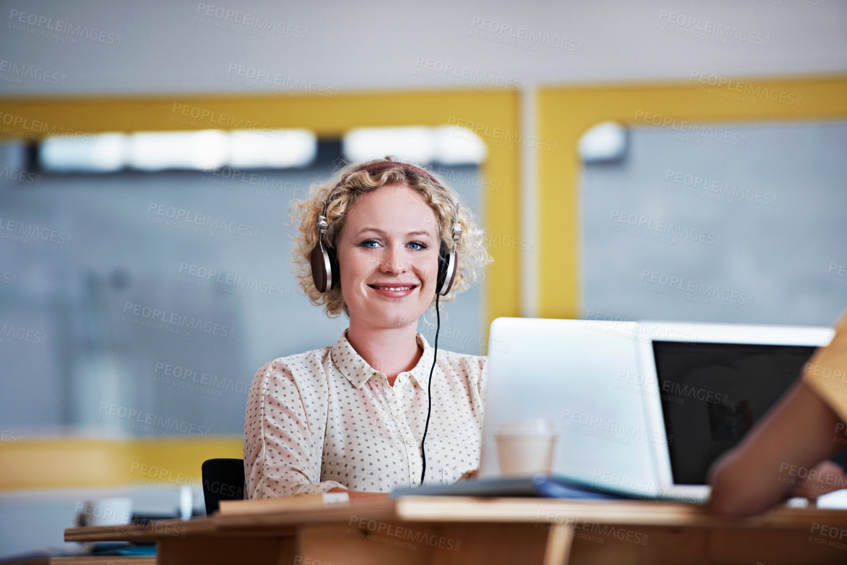 Buy stock photo Portrait of an attractive woman sitting at her desk working on a laptop in a modern office
