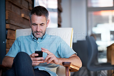 Buy stock photo Shot of a man sending a text message while taking a work break