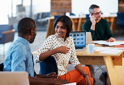 Buy stock photo Shot of two coworkers talking together at a desk in an office