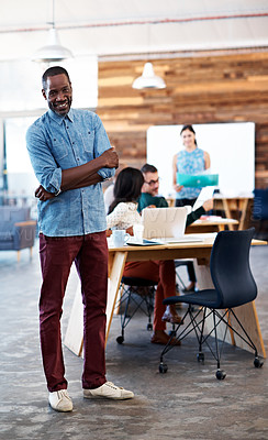 Buy stock photo Portrait of a young man standing in an office with colleagues in the background