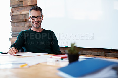 Buy stock photo Portrait of a mature businessman sitting at a table in an office