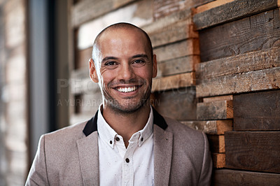 Buy stock photo Portrait of a handsome businessman leaning against a wall in an office