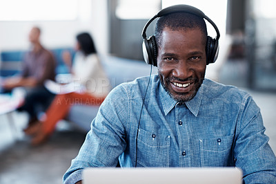 Buy stock photo Portrait of a man working on his laptop wearing a headset