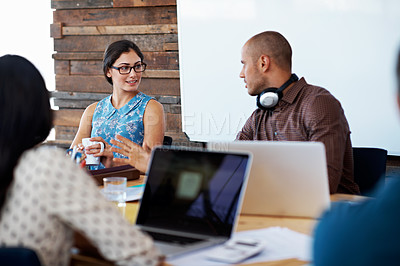 Buy stock photo Shot of a group of colleagues working on laptops around a table