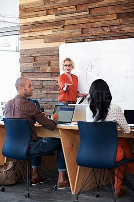 Buy stock photo Shot of a female office worker giving a financial presentation to her colleagues