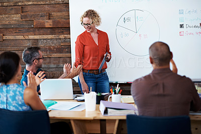Buy stock photo Shot of a female office worker giving a financial presentation to her colleagues