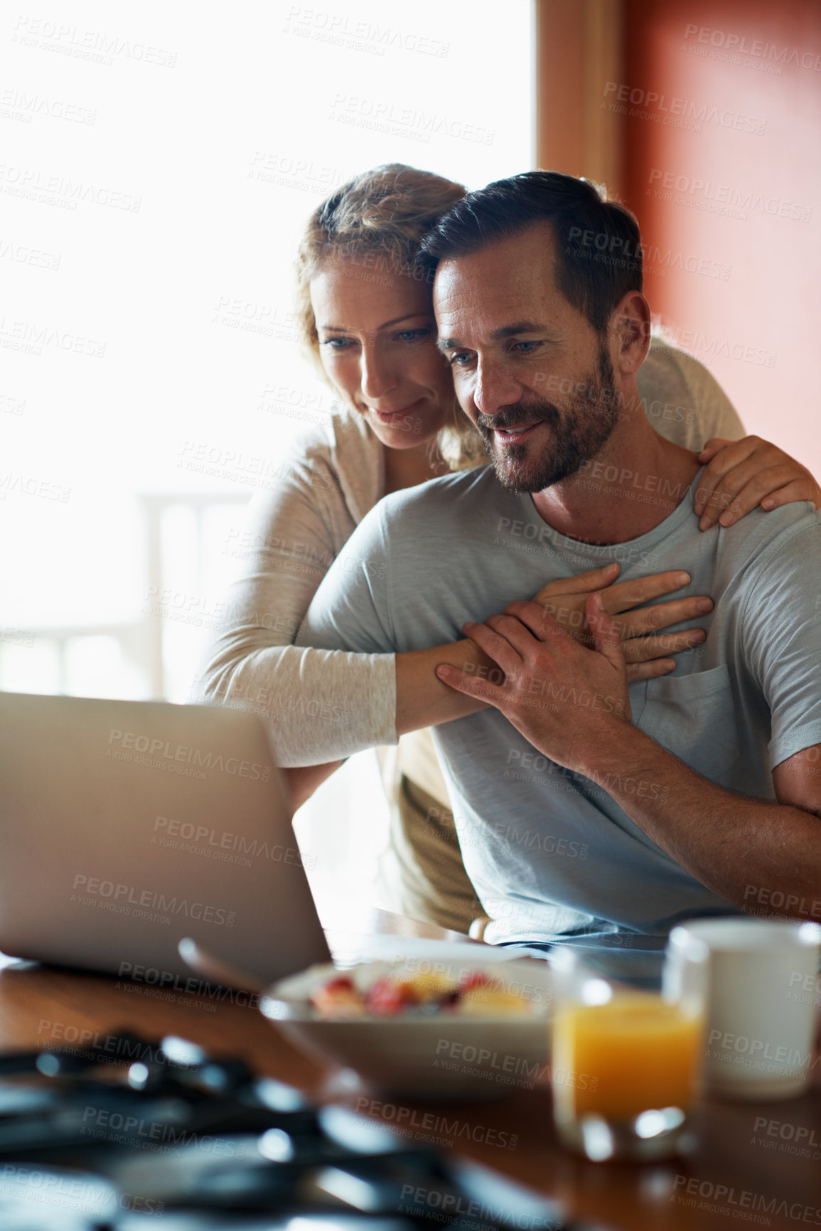 Buy stock photo Marriage, hug and couple on laptop in kitchen for website, internet and connection in morning. Happy, home and man with woman for bonding, love and embrace on computer for news, email and research