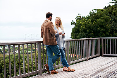 Buy stock photo Full length shot of a couple talking outside on their deck