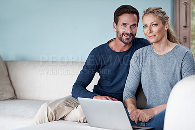 Buy stock photo Cropped shot of a couple using a laptop while relaxing on the sofa