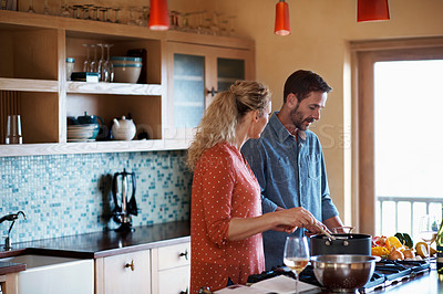 Buy stock photo Cropped shot of a couple cooking in the kitchen
