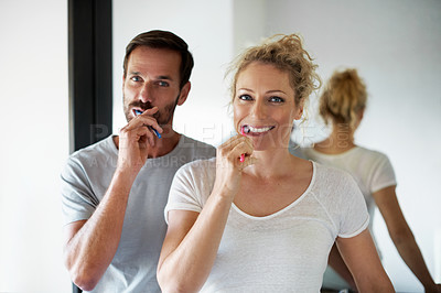 Buy stock photo Cropped portrait of a couple brushing their teeth in the bathroom