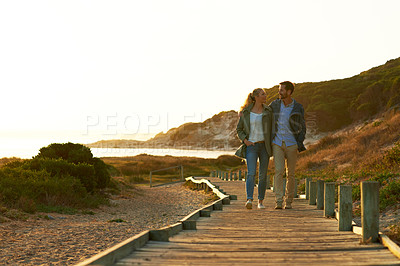 Buy stock photo Full length shot of an affectionate couple walking outdoors
