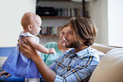 Buy stock photo Shot of a young couple playing with their baby at home