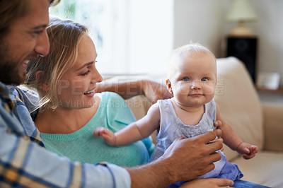 Buy stock photo Shot of a young couple playing with their baby at home