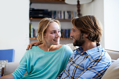 Buy stock photo Shot of a young couple relaxing on a sofa at home