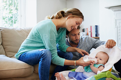 Buy stock photo Shot of a young couple playing with their baby at home
