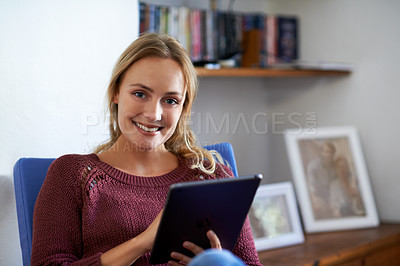 Buy stock photo Portrait of a young womman using a digital tablet while relaxing at home