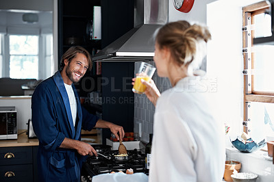 Buy stock photo Shot of a young couple cooking breakfast together in the kitchen