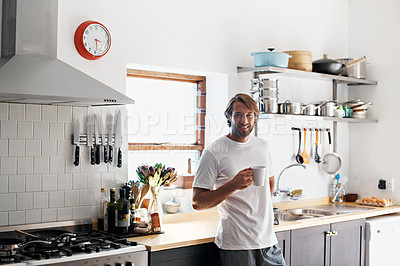 Buy stock photo Portrait of a young man drinking a coffee in the kitchen in the morning