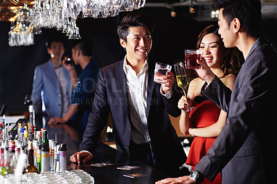 Buy stock photo Shot of a group of friends drinking together in a bar