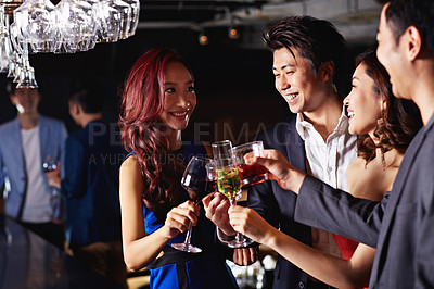 Buy stock photo Shot of a group of friends celebrating with drinks in a nightclub