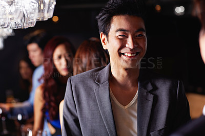 Buy stock photo Portrait of a handsome young asian man enjoying a night out in a bar