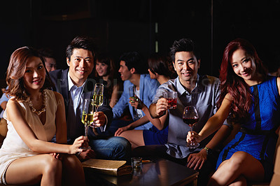 Buy stock photo Portrait of a group of young friends enjoying a night out together in a bar