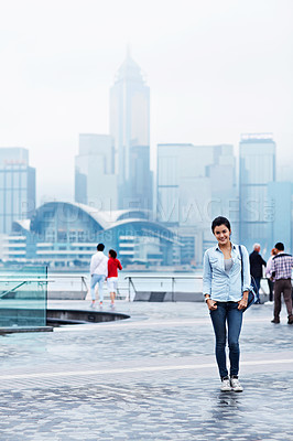 Buy stock photo Portrait of an attractive young asian woman standing in front of the Hong Kong skyline