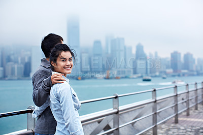 Buy stock photo Portrait of a young asian couple enjoying the view of the Hong Kong skyline