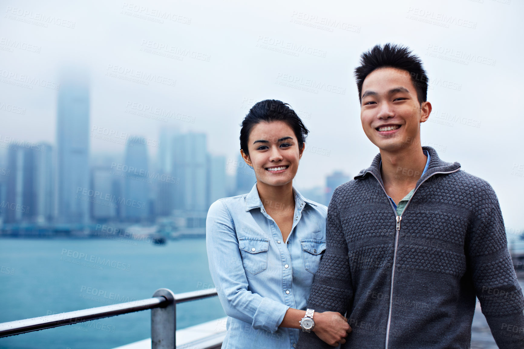 Buy stock photo Travel, asian couple and happy at waterfront in city for holiday abroad, sightseeing and bonding. Tourist, people and portrait outdoor for urban tourism, overseas vacation and relationship connection