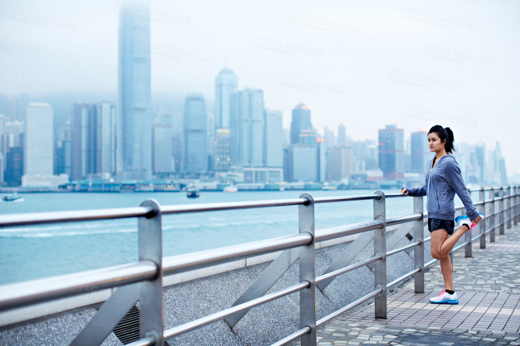 Buy stock photo Stretching, legs and Asian woman on bridge for fitness, workout and ready for runner challenge. Sports, city and person warm up for training, wellness and active for health and exercise in Hong Kong