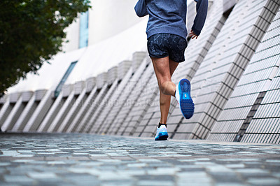 Buy stock photo Cropped low angle shot of a woman jogging