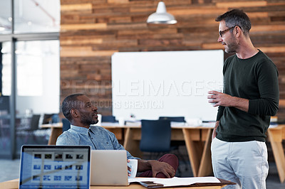 Buy stock photo Shot of two colleagues having a discussion at a desk