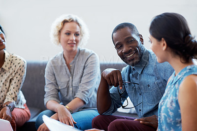 Buy stock photo Shot of a group of colleagues sitting together on a sofa