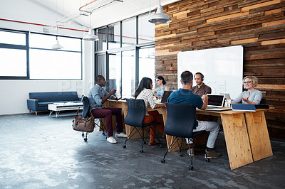 Buy stock photo Shot of a group of colleagues working on laptops around a table