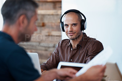 Buy stock photo Portrait of a man wearing headphones at his desk with his colleagues in the foreground