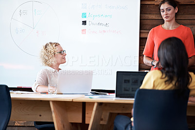 Buy stock photo Shot of a female office worker giving a financial presentation to her colleagues