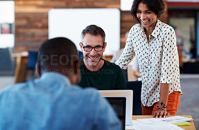 Buy stock photo Shot of a group of colleagues having a discussion at a desk
