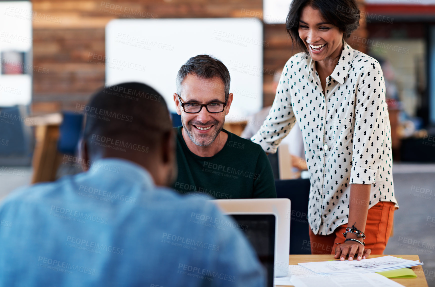 Buy stock photo Shot of a group of colleagues having a discussion at a desk