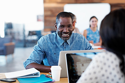 Buy stock photo Portrait of a designer sitting at his desk with his colleagues blurred out