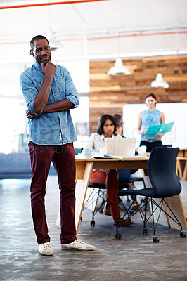 Buy stock photo Portrait of a handsome designer with his colleagues blurred in the background