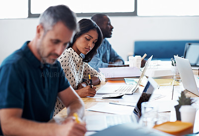 Buy stock photo Shot of a group of coworkers using laptops at a desk