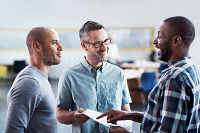 Buy stock photo Shot of a group of colleagues discussing paperwork