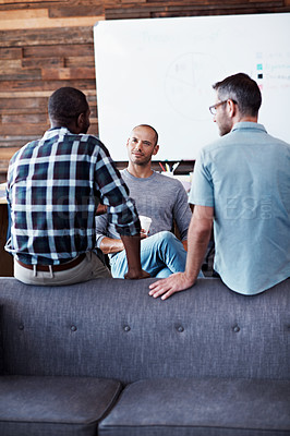 Buy stock photo Shot of a group of male colleagues having a conversation in an modern office