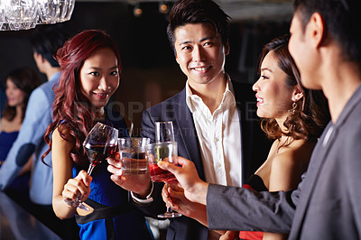 Buy stock photo Shot of a group of friends celebrating with drinks in a nightclub