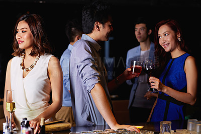 Buy stock photo Shot of a young asian people enjoying themselves in a bar