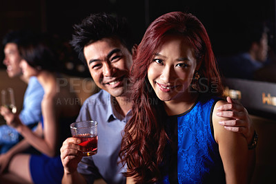 Buy stock photo Portrait of a young couple enjoying a night out together in a bar