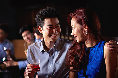 Buy stock photo Shot of a young couple enjoying a night out together in a bar