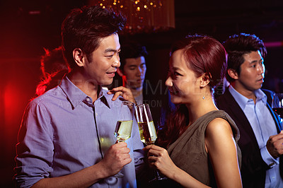 Buy stock photo Shot of a young couple enjoying a night out together in a bar