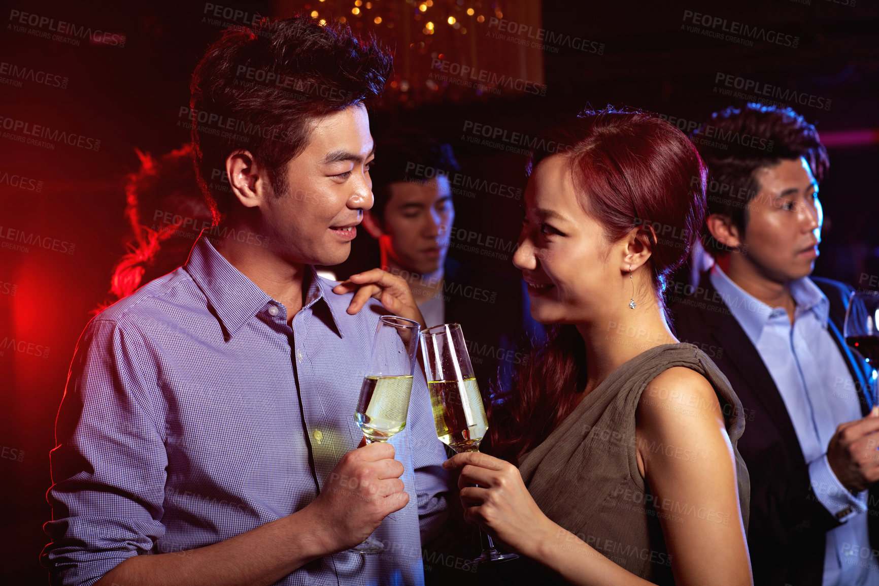 Buy stock photo Shot of a young couple enjoying a night out together in a bar